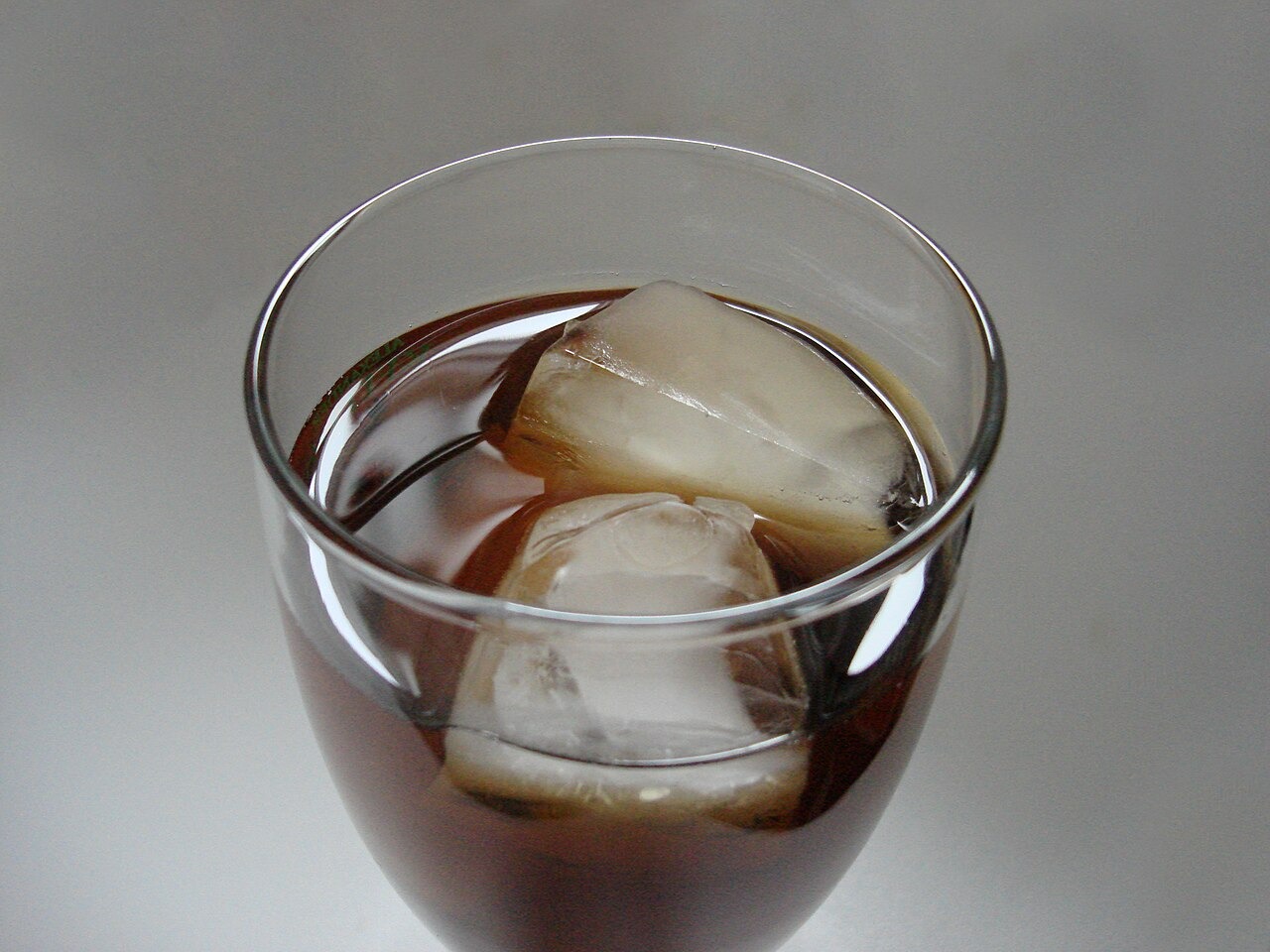A tall glass of amber iced tea with ice cubes